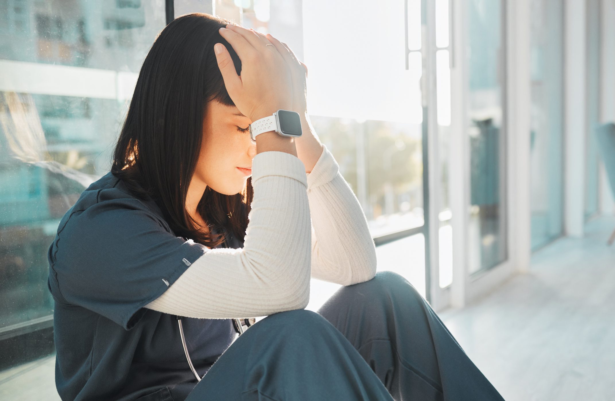 A nurse with her hands on her head upset.